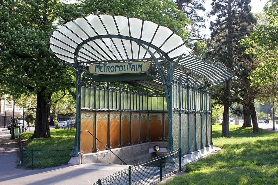 Édicule d'entrée du métro parisien en fonte peinte en vert, avec sa marquise de verre en éventail et l'enseigne Métropolitain