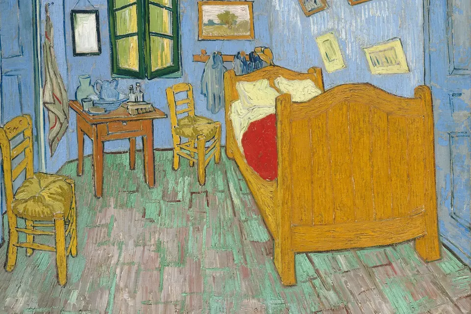 Tableau d'une petite chambre aux murs bleus avec un lit en bois jaune, deux chaises paillées, une table de toilette et une fenêtre entrouverte